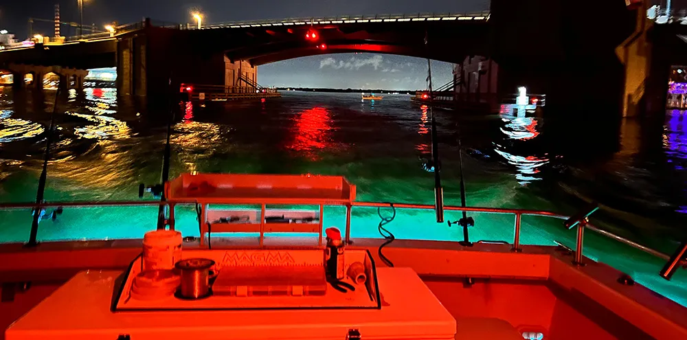 The view aft from the deck as the boat passes under the Johns Pass bridge at night